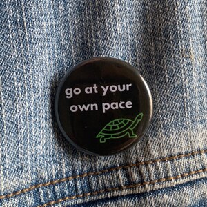 May include: Black button with white text that reads "go at your own pace" and a green outline of a turtle.