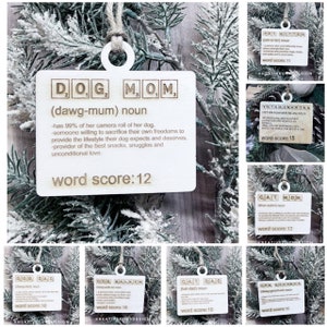 May include: A set of ten wooden ornaments with a Scrabble tile design. Each ornament features a different word related to pets, such as "Dog Mom", "Cat Dad", "Dog Walker", and "Pet Sitter". The ornaments are decorated with a brown wood finish and have a white background.