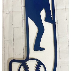 May include: A blue wooden letter J with a baseball player silhouette and a baseball inside the letter. The baseball has white stitching.