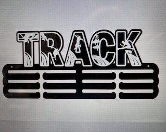 以下が含まれることがあります： 黒い金属製のメダルディスプレイラックで、大きな文字で「TRACK」と書かれています。文字は、サーフィンをしている白いシルエットの人々で飾られています。