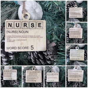 May include: A set of ten wooden ornaments shaped like Scrabble tiles, each representing a different profession. The ornaments are decorated with the name of the profession, a definition, and a word score. The professions include Nurse, Dentist, Veterinarian, Doctor, Hygienist, Midwife, and Physician.