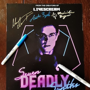 May include: A black and white poster with the title "Seven Deadly Synths" in pink and blue neon lettering. The poster features a man with glasses and a purple face in a neon blue and pink geometric shape. The poster is signed by three people in gold ink.
