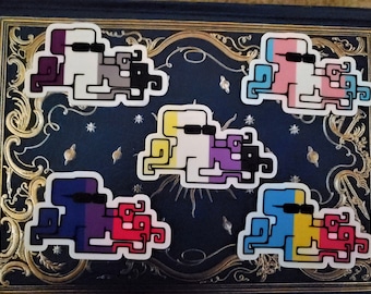 May include: Five colorful stickers of a pixelated character wearing sunglasses. The stickers are in the colors of the asexual, transgender, non-binary, pansexual, and genderfluid pride flags.