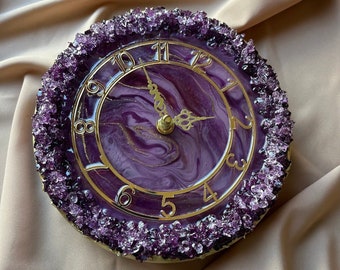 May include: A purple and gold clock with a marbled face surrounded by amethyst crystals.