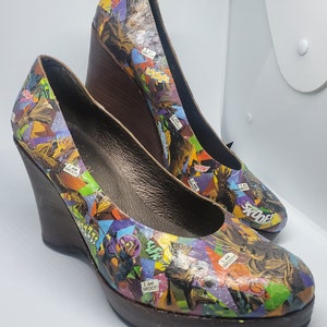 May include: A pair of brown wedge shoes with a colorful comic book print featuring the phrase "I am Groot!" and other characters.