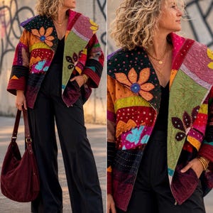 May include: A quilted jacket featuring a vibrant patchwork design with floral and geometric patterns in shades of red, orange, green, and purple. The jacket has a wide collar, long sleeves, and front pockets, paired with black trousers and a dark red hobo bag.