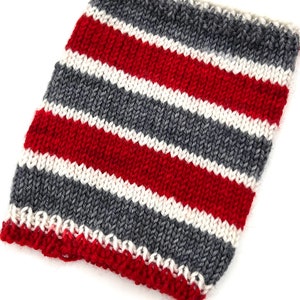 May include: A knitted fabric swatch with red, white, and gray stripes. The fabric is knit in a simple stitch.