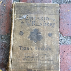 May include: A vintage, brown, third reader book with the title "The Ontario Readers" and "Third Reader" printed on the cover. The book is authorized by the Minister of Education and costs 36 cents.