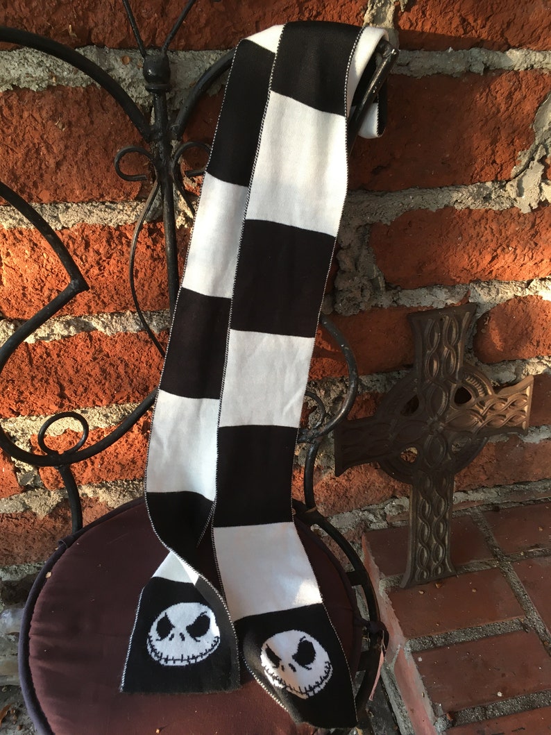 Op de afbeelding: Zwart-wit geblokte sjaal met een zwart-wit Jack Skellington gezicht aan elk uiteinde.