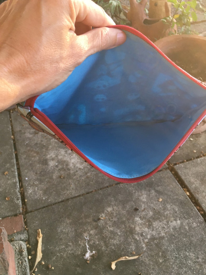 Op de afbeelding: Een rode ritszak met een blauwe voering. De zak is open en de voering is zichtbaar.