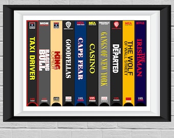 May include: A framed print featuring a collection of classic movie titles on VHS tapes, including "Taxi Driver," "Goodfellas," and "The Irishman." The titles are displayed in bold, contrasting colors against a black background.