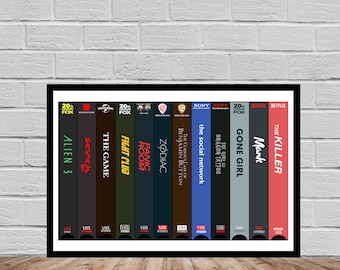 May include: A framed print of a collection of VHS tapes, each with a different movie title. The titles include "Alien 3", "Seven", "The Game", "Fight Club", "Panic Room", "Zodiac", "The Curious Case of Benjamin Button", "The Social Network", "The Girl with the Dragon Tattoo", "Gone Girl", "Mank", and "The Killer".