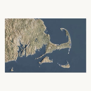 May include: A satellite view map of Cape Cod and the surrounding Massachusetts coastline. The land is depicted in shades of tan, brown, and green, showing detailed topography and terrain, while the deep blue ocean surrounds the landmass.