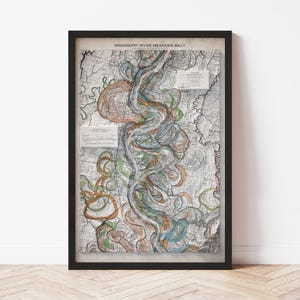 May include: Framed map print titled "Mississippi River Meander Belt." The map features a detailed illustration of the river's course, with colorful swirls of orange, green, and blue. The map is encased in a black frame, adding a classic touch.