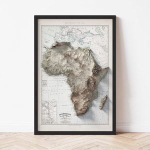 May include: Framed vintage map of Africa with a 3D topographic relief. The map is in shades of beige, brown, and gray, with the continent's landmass prominently displayed. The frame is black.