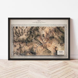 May include: A framed topographic map of The Hayduke Trail, featuring a detailed relief in shades of brown, tan, and green. The map is enclosed in a decorative border and a black frame. The text "The Hayduke Trail" is visible at the top.