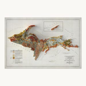 May include: A 1911 geological survey map of the Upper Peninsula of Michigan featuring a raised, three-dimensional relief of the landmass. The map displays various surface formations in shades of red, orange, yellow, and grey on a white background.
