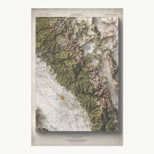 May include: A topographic map of the Eastern Sierra region in California, featuring detailed relief shading of mountain ranges in shades of green and brown, contrasted against a flat, grid-lined valley floor with small orange urban markers.