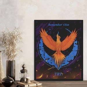 May include: Framed art print featuring a vibrant orange phoenix with outstretched wings against a dark background. The artwork includes the text "Remember this" and "TRY" with a blue circular design and flame accents.