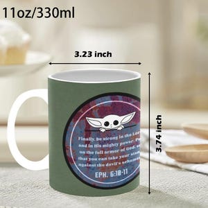 Pode incluir: Caneca de cer&acirc;mica com al&ccedil;a e interior brancos, com exterior verde e design circular. O design inclui um personagem de desenho animado e texto de Ef&eacute;sios 6:10-11. A caneca tem 8,2 cm de largura e 9,5 cm de altura.