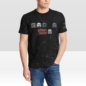 以下が含まれることがあります： 黒地にダメージ加工が施されたTシャツ。スターウォーズのクローン・トルーパーのヘルメット5つのグラフィックと、その下に「プラン99」の文字がプリントされている。
