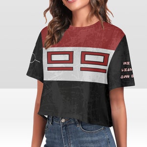 Könnte beinhalten: Ein schwarzes, weißes und rotes, bauchfreies T-Shirt mit einem Grafikdruck von drei roten Quadraten und dem Text "WE LEAVE OUR OWN DESTINY" auf der Seite.