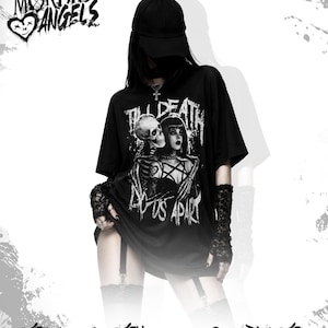 Könnte beinhalten: Schwarzes Grafik-T-Shirt mit dem Text "Till Death Do Us Apart" und einem Design mit einem Totenkopf und einer Frau. Das Shirt ist Teil der "Morbid Angels"-Kollektion. Das Model trägt eine schwarze Kappe und Spitzhandschuhe.