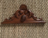 A classic French oak antique carved wooden pediment with naturalist scroll decorative details