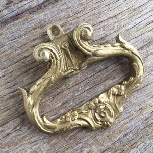 Ein einzelner vergoldetem bronzefarbenen Türgriff im Rokoko Stil