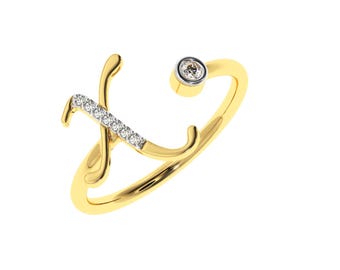 Puede incluir: Un anillo de oro con una letra 'X' engastada con diamantes y un solo diamante redondo en el lateral.