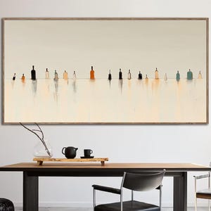 May include: A long, horizontal abstract painting with a white background and a row of colorful, vertical shapes in the center. The shapes are reminiscent of bottles or jars, and they are reflected in the water below. The painting is framed in a light wood frame.