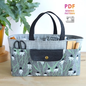 May include: A rectangular sewing basket with a gray floral print pocket and black handles. The basket contains sewing tools and fabric. The text "PDF Sewing Pattern" is in the upper right corner.