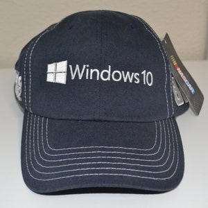May include: A navy blue baseball cap with a white embroidered Windows 10 logo and a white NASCAR tag.