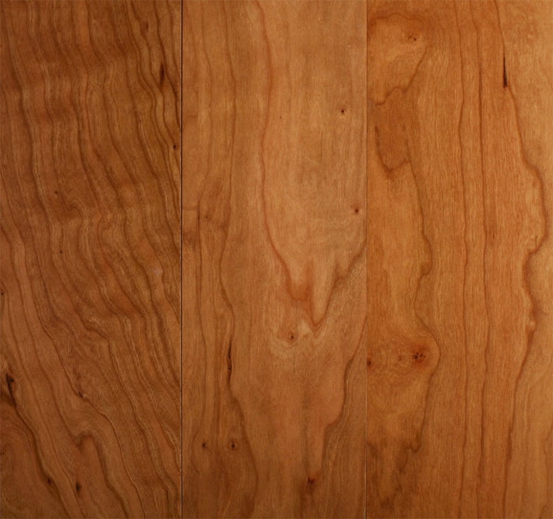 以下が含まれることがあります： 自然なチェリー仕上げのウッドフロアのクローズアップ。木目ははっきりと見え、暖かみのある赤褐色をしています。