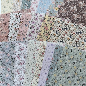 May include: A collection of rectangular sheets featuring diverse floral and butterfly patterns in various colour palettes including cream, pink, blue, green, yellow, and brown. Each sheet displays intricate botanical illustrations and insects.
