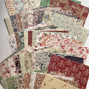 May include: A selection of patterned paper sheets with floral and botanical designs. The papers display a variety of colours, including red, pink, blue, green, and brown, with diverse floral and leaf patterns. The papers are arranged in a fan shape.