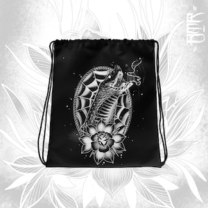 May include: Black drawstring bag with a white graphic of a snake with its mouth open, surrounded by a spiderweb and a flower. The text "TOOTH" is printed on the bag.