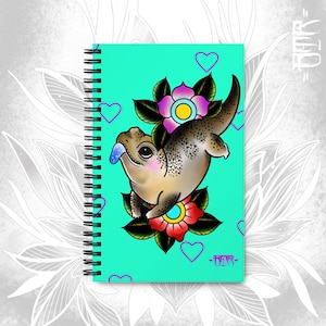 May include: A teal blue notebook cover with a cartoon illustration of a brown lizard with a blue tongue, surrounded by pink and red flowers. The text "OOPS" is printed in the bottom right corner.