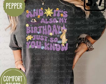 May include: A black t-shirt with a purple graphic that says "And it's also my birthday just so you know". The graphic features a sun, flowers, and a cartoon character. The text "Pepper" is in a green circle in the top left corner and the text "Comfort Colors" is in a green circle in the bottom left corner.