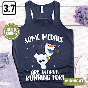 Könnte beinhalten: Ein marineblaues Tanktop mit einer weißen Grafik von Olaf aus Frozen. Die Grafik sagt "Manche Medaillen sind das Laufen wert!" und hat ein Sternenmuster im Hintergrund. Der Text "Farbe MITTERNACHT" befindet sich in der rechten unteren Ecke.