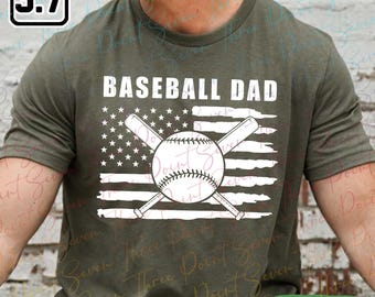 May include: Heather military green t-shirt with the text "BASEBALL DAD" in white. The design features a baseball, crossed bats, and an American flag graphic. The shirt is a heather military color.