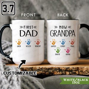 Peut inclure: Mug en céramique blanche avec anse et bord noir. Devant: "FIRST DAD" avec empreintes de mains colorées et noms. Derrière: "NOW GRANDPA" avec empreintes et noms. Personnalisable, capacité de 444 ml.
