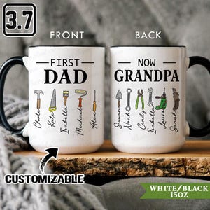 Könnte beinhalten: Weiße Keramiktasse mit schwarzem Griff und Rand, mit dem Text "FIRST DAD" und "NOW GRANDPA" mit Werkzeugen und Namen. Die Tasse ist anpassbar und fasst 444 ml.