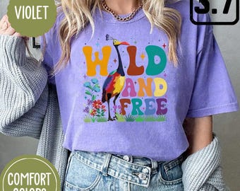 May include: A purple t-shirt with a colorful graphic of a bird and the text "WILD AND FREE" in a retro font.