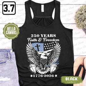 Puede incluir: Camiseta sin mangas negra con un dise&ntilde;o patri&oacute;tico que presenta un &aacute;guila con las alas extendidas, una cruz y el texto "250 YEARS Faith & Freedom 1776-2026". La camiseta sin mangas Bella Canvas tiene un estilo de espalda nadadora.