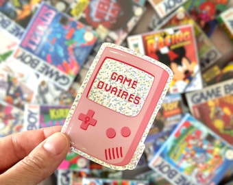 Feminist sticker in a glitter vinyl of a vintage game console with the wordplay &quot;Game ovaires&quot; in french for exterior or customizing objects