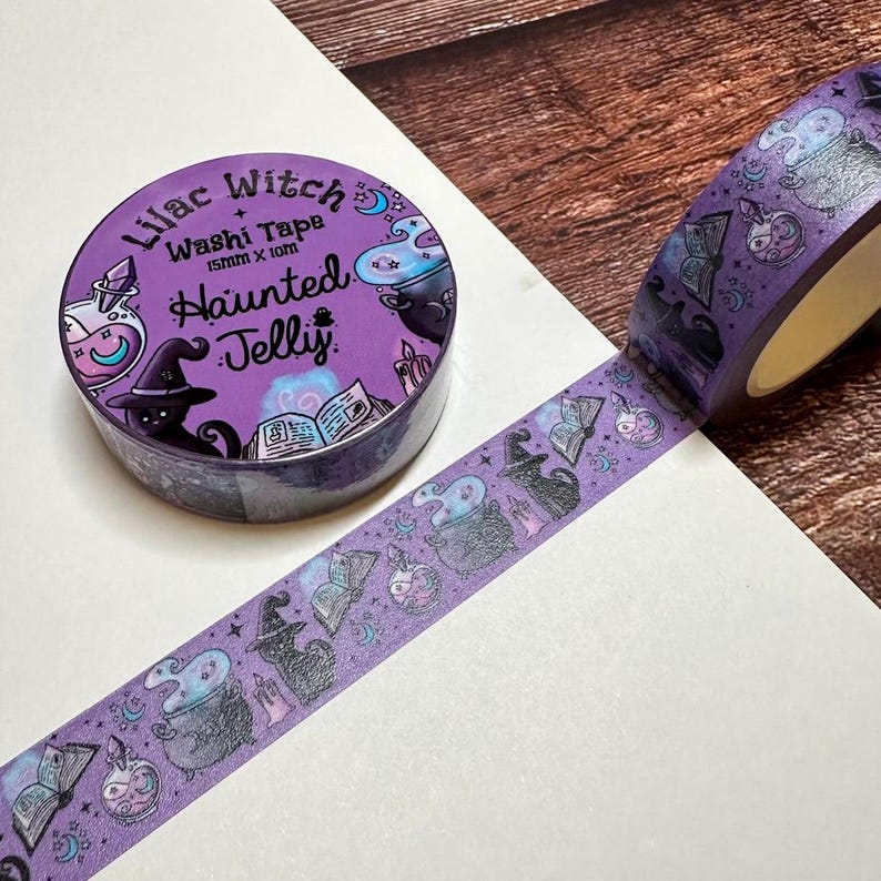 May include: A roll of purple washi tape with a spooky Halloween theme. The tape features illustrations of witch hats, potion bottles, and cauldrons. The tape roll is labeled "Lilac Witch Washt Tape Haunted Jelly". The tape is 15mm x 10m.