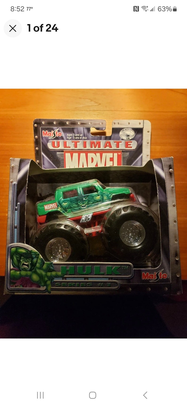 Op de afbeelding: Een groen en zwart monstertruck speelgoed met de woorden "Ultimate Marvel" en "Hulk" op de verpakking. De truck heeft een groene carrosserie met een Hulk-afbeelding en de woorden "Marvel" aan de zijkant. De truck staat op een zwarte en zilveren achtergrond.