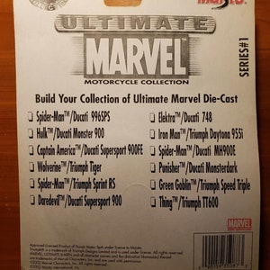 Op de afbeelding: Een witte kaart met een zwart en rood logo voor Maisto's Ultimate Marvel Motorcycle Collection. De kaart vermeldt de verschillende Marvel-personages en motorfietsen die in de collectie zijn opgenomen. De tekst op de kaart luidt "Build Your Collection of Ultimate Marvel Die-Cast".