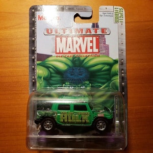 Op de afbeelding: Een groene speelgoedauto van gegoten metaal met de tekst "The Incredible Hulk" aan de zijkant. De auto zit in een plastic verpakking met een afbeelding van Hulk op de achterkant. De verpakking is gelabeld met "Ultimate Marvel Die-Cast Collection Serie #1 #120/225".